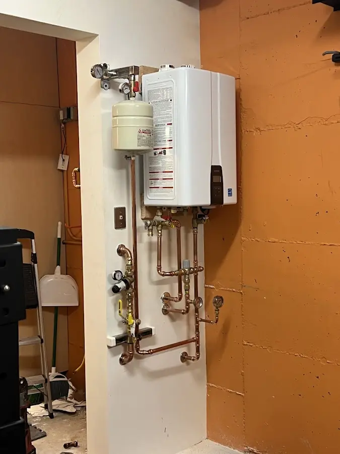 Plumbing technician inspecting water heater connections in Presque Isle